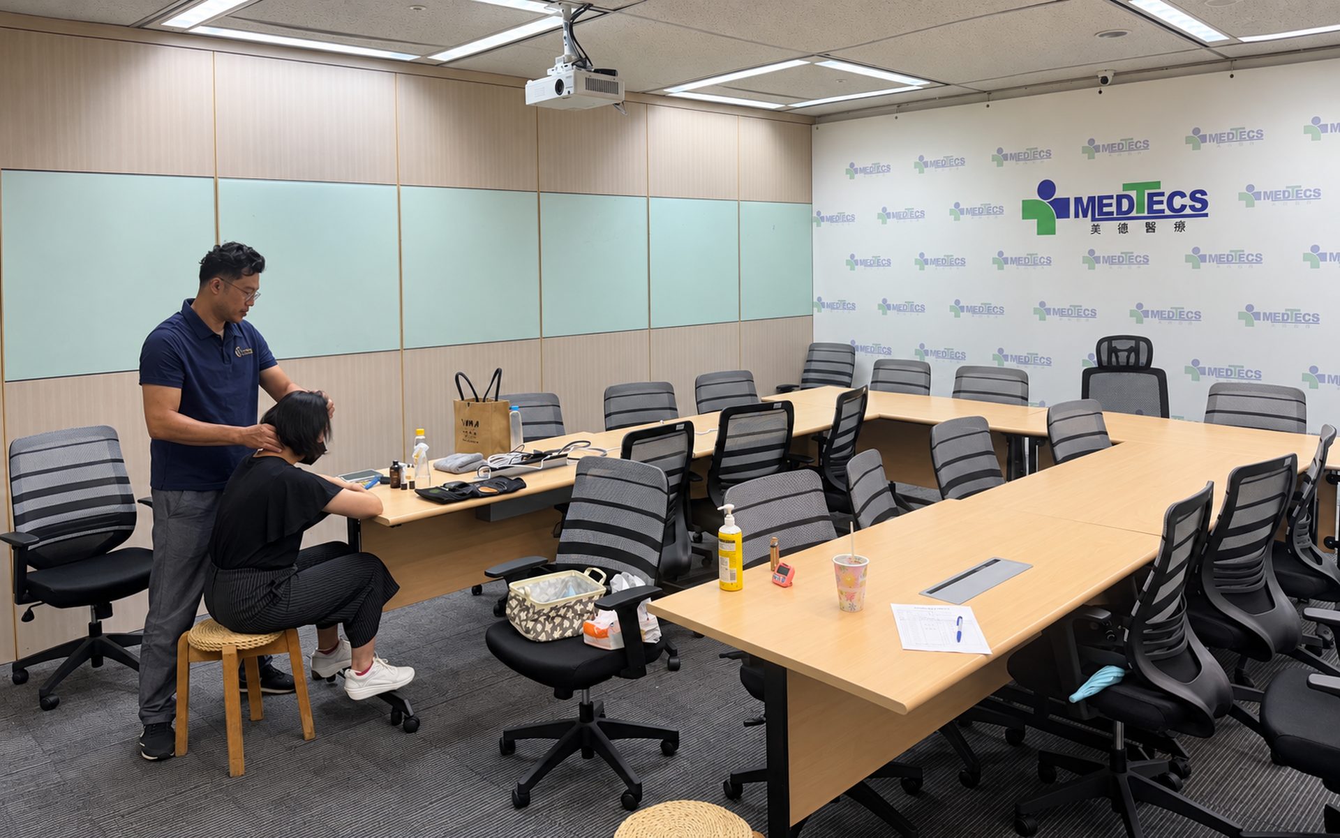 Medtecs 會議室裡，師資為坐在椅子上的同仁按摩肩頸