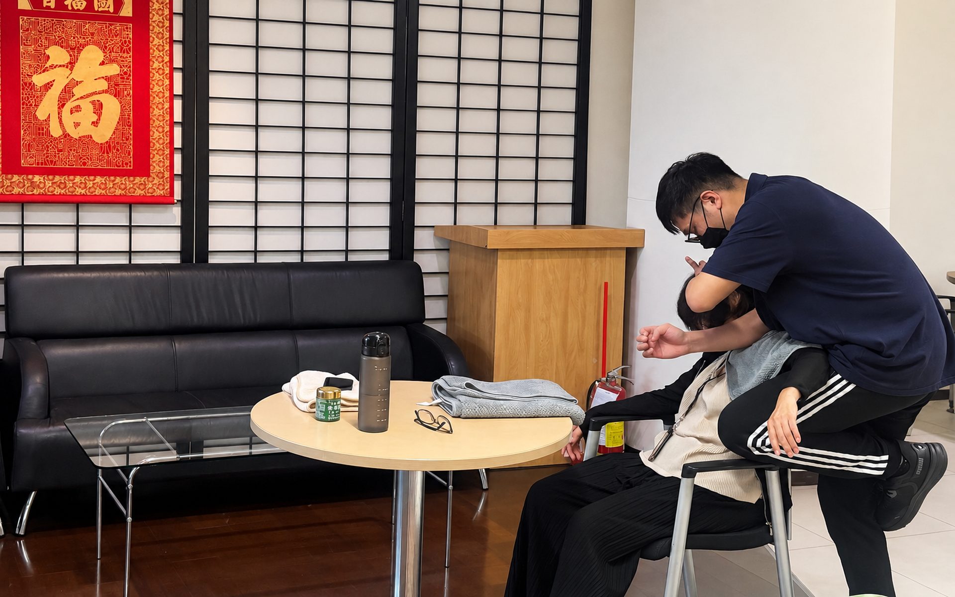 辦公室休息區，師資為坐姿同仁按摩肩頸